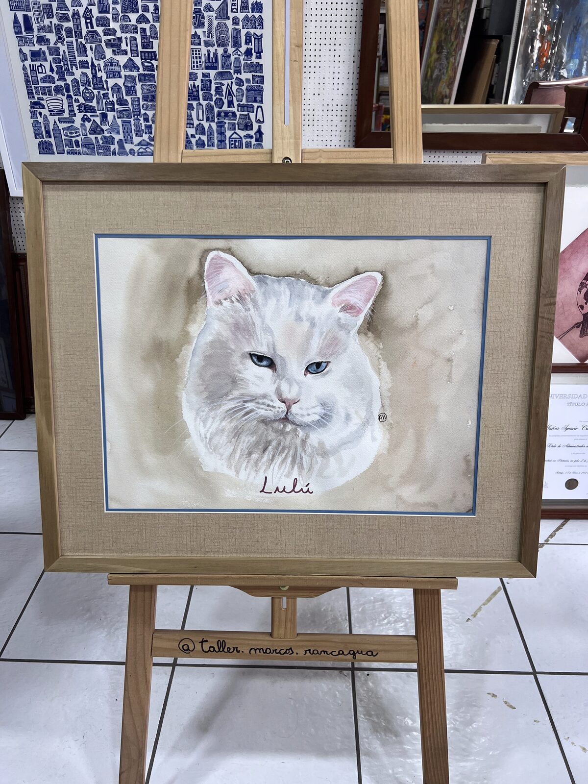 Acuarela de la gata Lulú enmarcada con paspartú tipo arpillera, filete celeste y moldura de madera natural