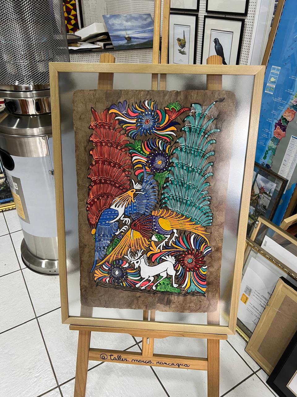 Arte huichol sobre papel amate con aves y venado enmarcado