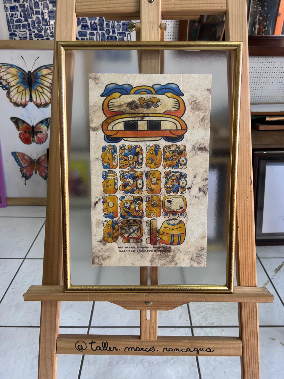 Amate con figuras prehispánicas enmarcado en marco dorado