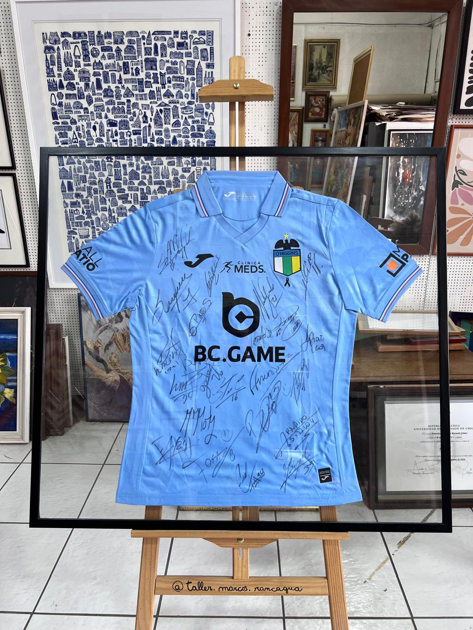 Camiseta deportiva celeste firmada enmarcada en shadow box