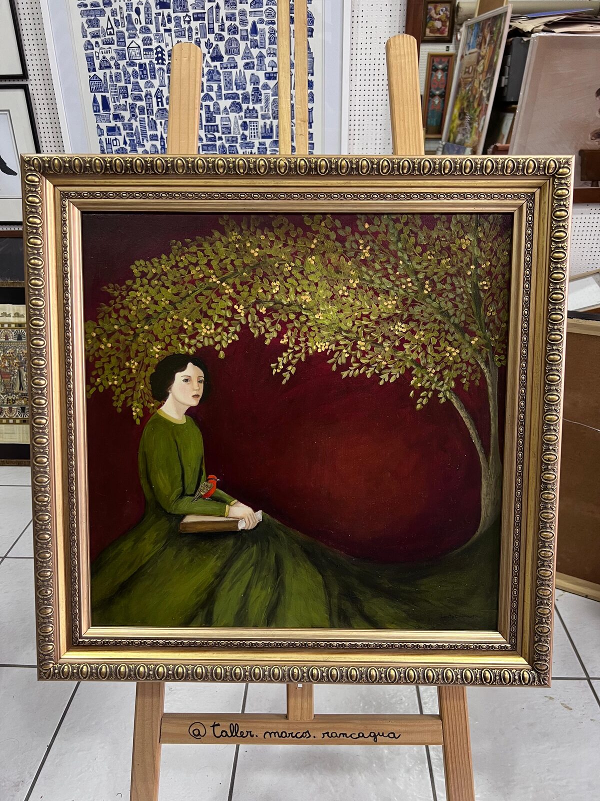 Óleo de mujer bajo un árbol, fondo burdeo, enmarcado en marco dorado