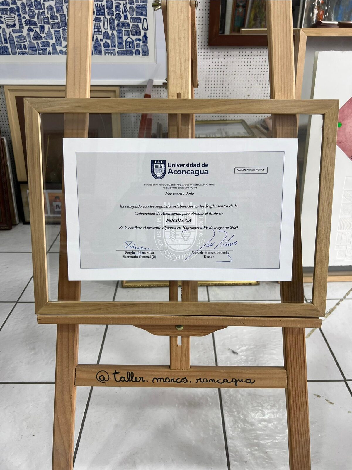 Título universitario enmarcado entre cristales con moldura de madera natural