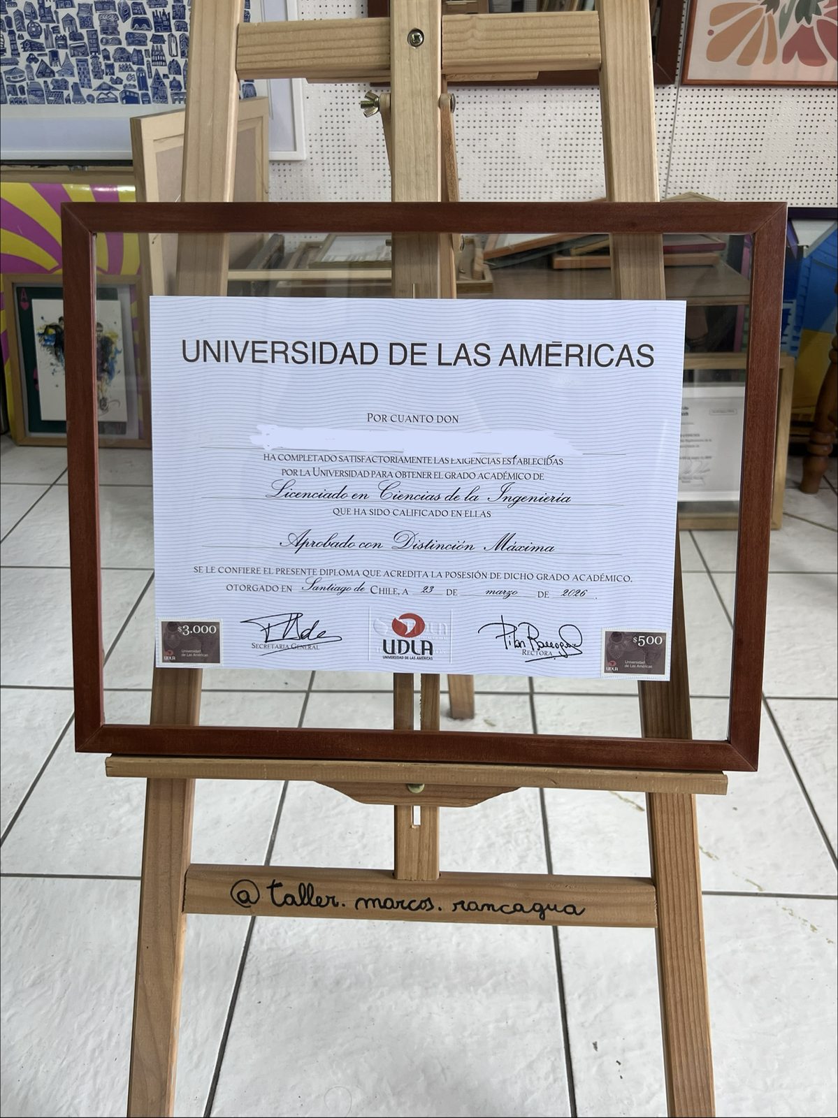 Título universitario enmarcado entre cristales con moldura alerce oscuro
